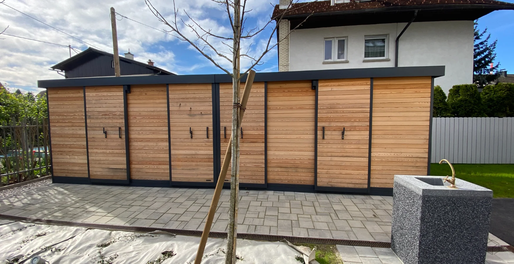 Gartenh&auml;user vor einem Mehrfamilienhaus